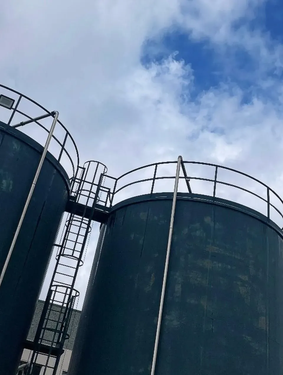 Due silos ancora scuri, prima della verniciatura, visti dal basso